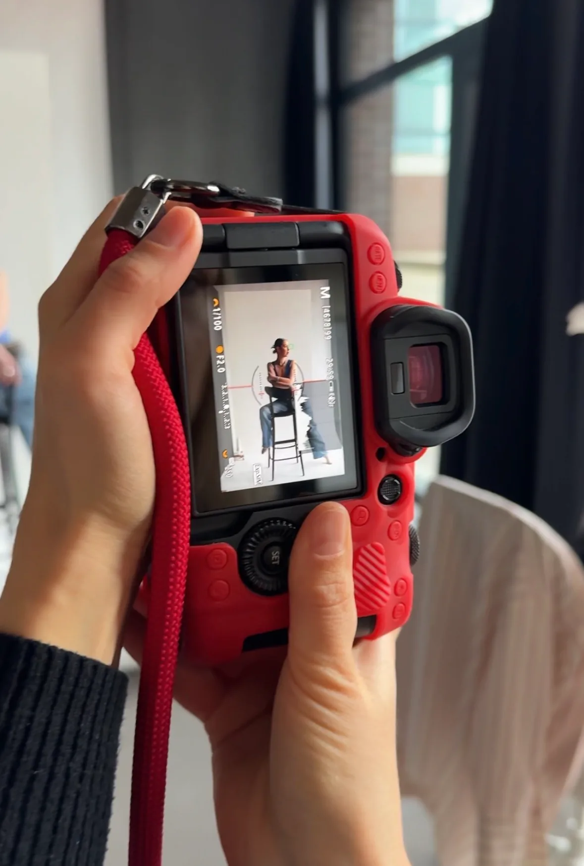 Red camera in the studio showing a model on its display during a photo shoot.