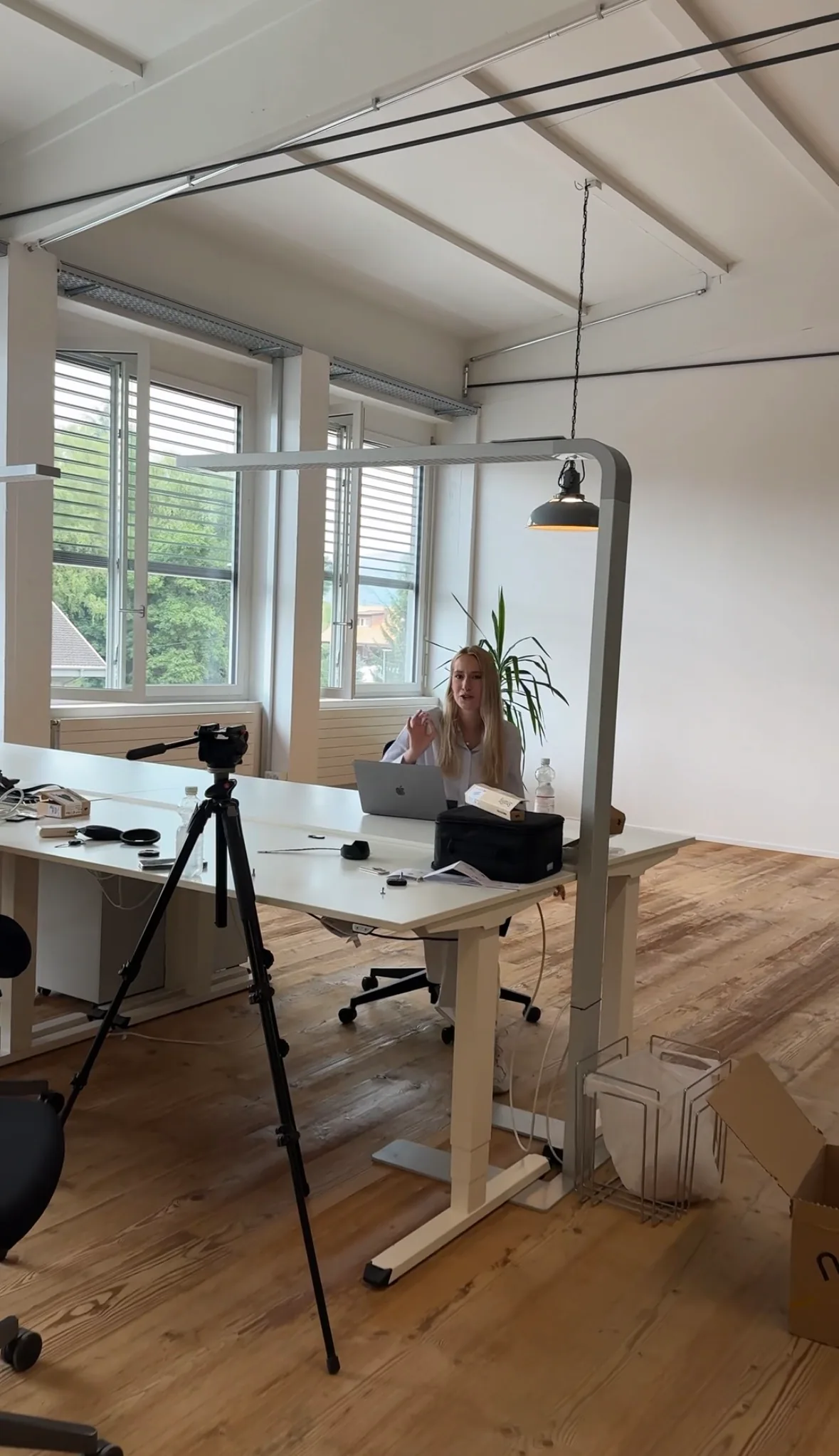 Videoaufnahme im Büro: Kamera auf Stativ filmt eine Person am Schreibtisch.