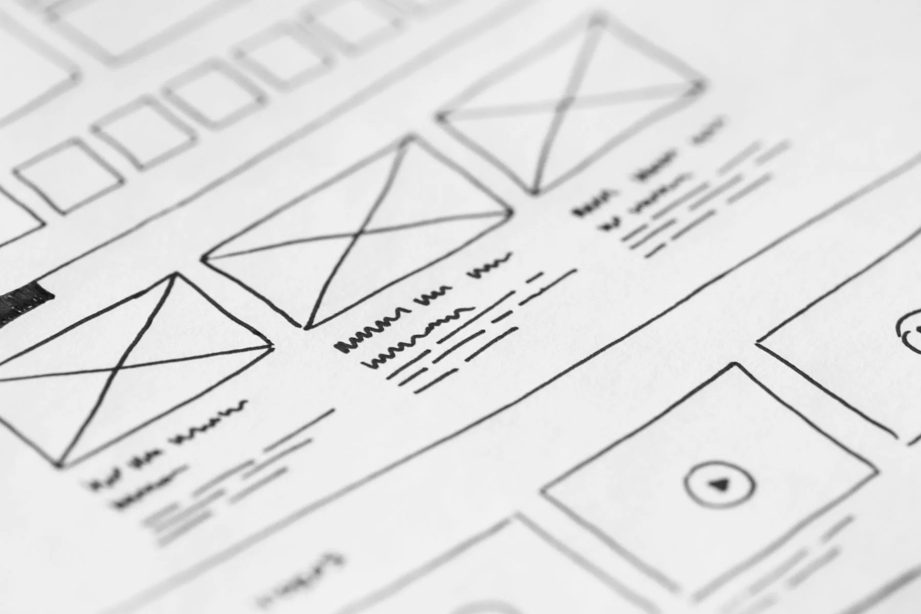 Hand-drawn website wireframes on paper, shot close up.